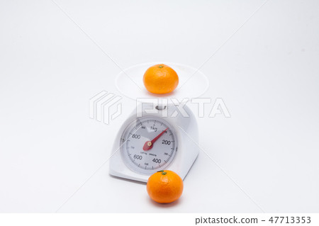 Healthy mandarin oranges on balance scale Healthy mandarin oranges on balance scale 47713353