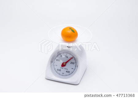 Healthy mandarin oranges on balance scale Healthy mandarin oranges on balance scale 47713368