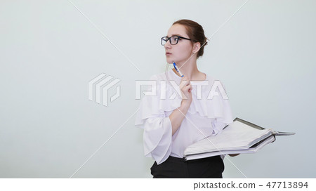 A schoolgirl in glasses depicts a successful girl with notes. A student depicts a reverie. The A schoolgirl in glasses depicts a successful girl with notes. A student depicts a reverie. The 47713894
