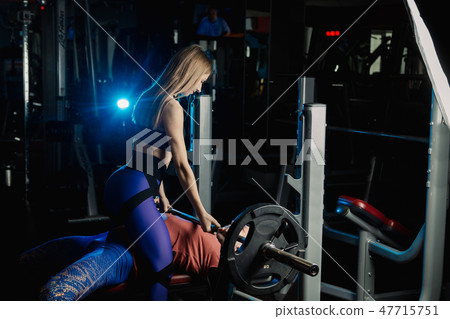 Female trainer helping guy to train in the gym Bar Female trainer helping guy to train in the gym Bar 47715751