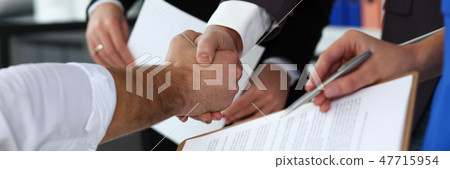 Man in suit and tie give hand as hello in office closeup Man in suit and tie give hand as hello in office closeup 47715954