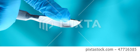 Surgeon arms in sterile uniform holding sharp knife Surgeon arms in sterile uniform holding sharp knife 47716385