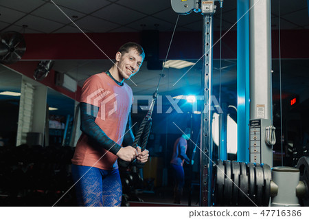 Handsome athletic man trains triceps on the block Handsome athletic man trains triceps on the block 47716386