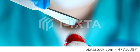 Surgeon in sterile uniform arms holding tools with bio material Surgeon in sterile uniform arms holding tools with bio material 47716387