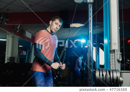 Handsome athletic man trains triceps on the block Handsome athletic man trains triceps on the block 47716389