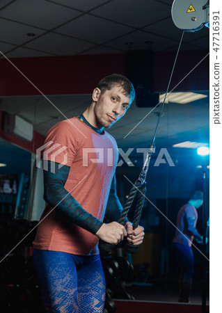 Handsome athletic man trains triceps on the block Handsome athletic man trains triceps on the block 47716391