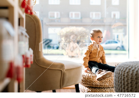 A small toddler boy sitting in zero waste shop. Copy space. 47716572