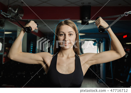 Active beautiful fitness model girl trains biceps Active beautiful fitness model girl trains biceps 47716712