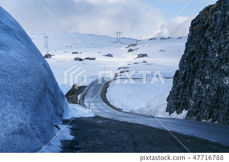 Road in mountains through the snow covered landscape, Norway in May. 47716788