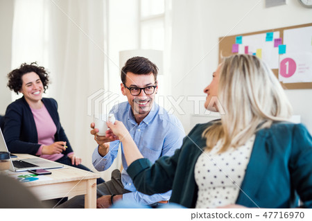 Group of young businesspeople working together in a modern office. Group of young businesspeople working together in a modern office. 47716970