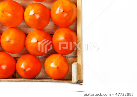 Juicy ripe persimmon in a large wooden box 47722895