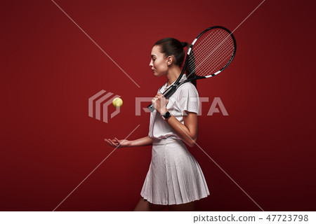 Talk with your raquet, play with your heart. Young tennis player standing isolated over red 47723798
