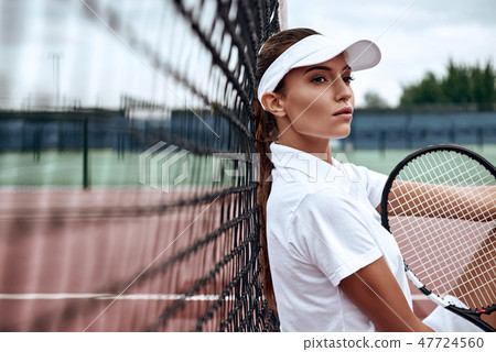 Push yourself again and again. Portrait of young female tennis player sitting on a court after match Push yourself again and again. Portrait of young female tennis player sitting on a court after match 47724560