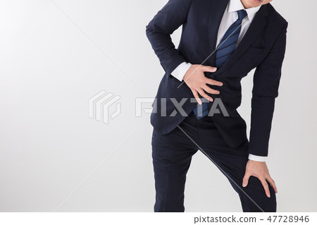 A scene where a man with a suit holds his stomach with a white background and is receiving physical condition and shock 47728946