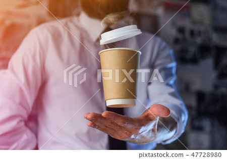 A waiter and a hovering cup of hot coffee 47728980