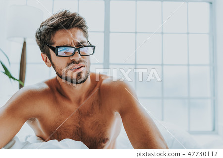 Upset young guy wakes up in morning Upset young guy wakes up in morning 47730112