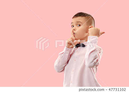 The teen boy whispering a secret behind her hand over pink background The teen boy whispering a secret behind her hand over pink background 47731102