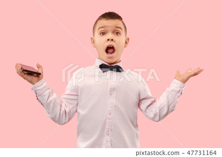 The young attractive teen boy looking suprised isolated on pink The young attractive teen boy looking suprised isolated on pink 47731164