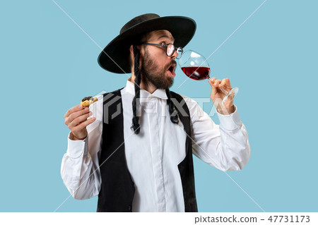 The young orthodox Jewish man with black hat with Hamantaschen cookies for Jewish festival of Purim 47731173