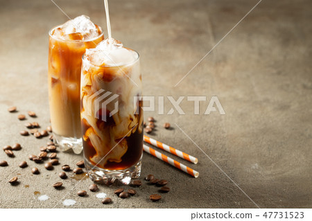 Ice coffee in a tall glass with cream poured over. Ice coffee in a tall glass with cream poured over. 47731523