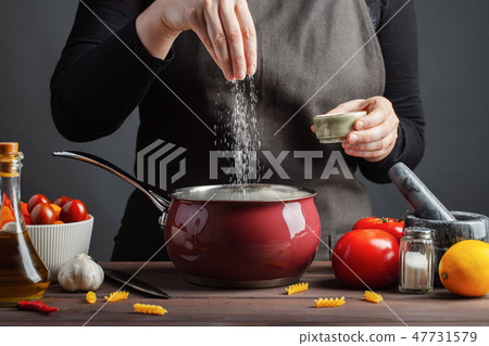 The chef preparations spaghetti and pasta. 47731579