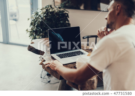 Laptop with empty monitor standing near blurred man 47731580