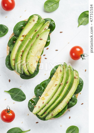 Two ciabatta toast with sliced avocado. Two ciabatta toast with sliced avocado. 47731584