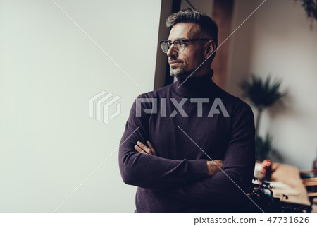 Adult man standing in cafe and looking aside 47731626