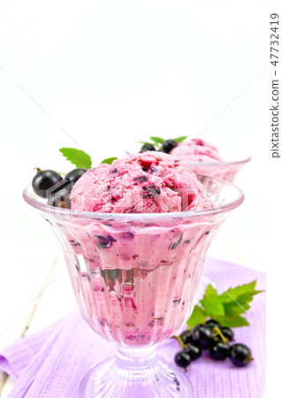Ice cream with black currant in glasses on board Ice cream with black currant in glasses on board 47732419