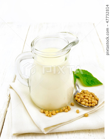 Milk soy in jug with leaf on board Milk soy in jug with leaf on board 47732814