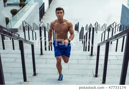 Orderly stripped to waist young man running 47733174