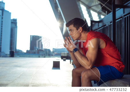 Thoughtful man in modern sport clothes dreaming outdoor Thoughtful man in modern sport clothes dreaming outdoor 47733232