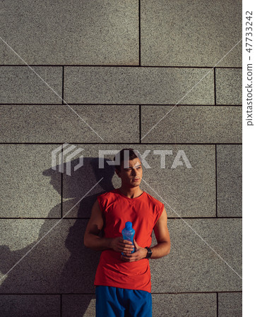 Serene male holding liquid in arms outdoor Serene male holding liquid in arms outdoor 47733242