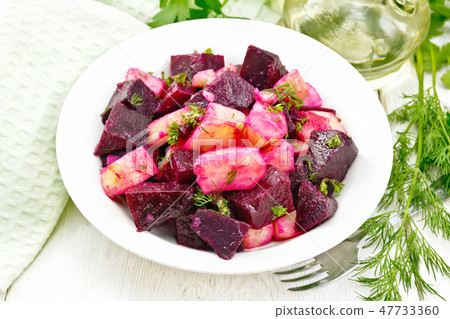 Salad of beets and potato in plate on wooden board 47733360