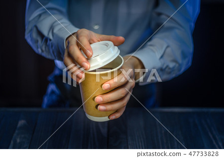 Barista serves coffee in a paper cup at the bar Barista serves coffee in a paper cup at the bar 47733828