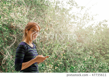 Portrait teenager woman with eyes glasses listen to music with earphone. Portrait teenager woman with eyes glasses listen to music with earphone. 47735611