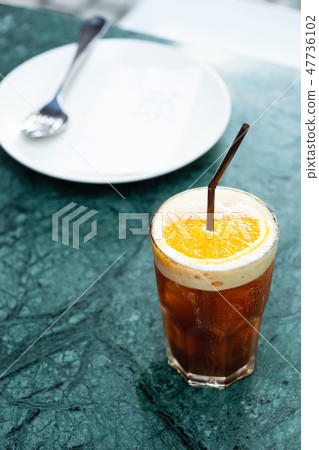 Iced coffee drink with orange slice 47736102