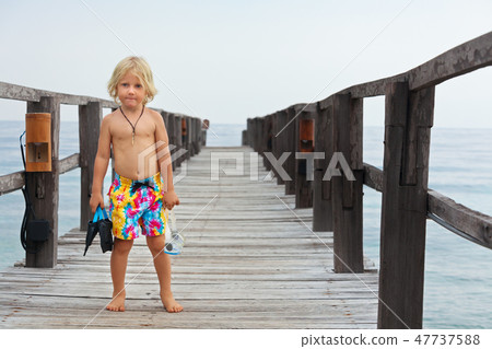 Child with mask, fins going to snorkel  47737588