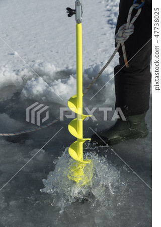 Ice auger drill drilling a hole in a frozen dam Ice auger drill drilling a hole in a frozen dam 47738025