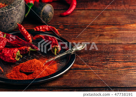 Ground and dried chili peppers on metal plate  47738191