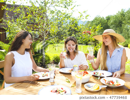 Happy female friends with glasses of lemonade Happy female friends with glasses of lemonade 47739468