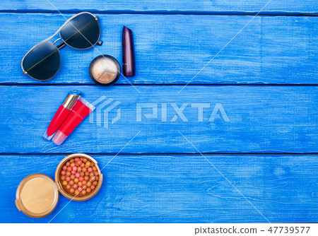 Makeup products on blue wood background Makeup products on blue wood background 47739577