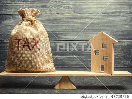 Wooden house and a money bag with the word Tax 47739726