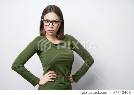 Strict woman in glasses standing looking at camera with intense look 47740406