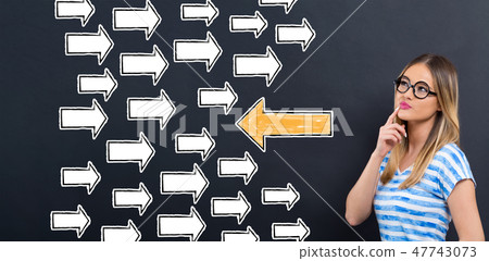 Arrow going in a opposite direction with young woman Arrow going in a opposite direction with young woman 47743073