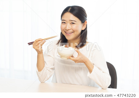A woman eating white rice A woman eating white rice 47743220