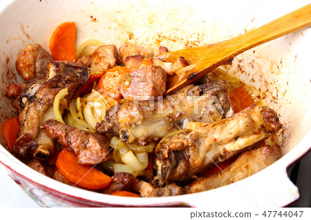 Cast iron plate with sliced grilled rib cooking a medium steak with fried potato and spices. 47744047