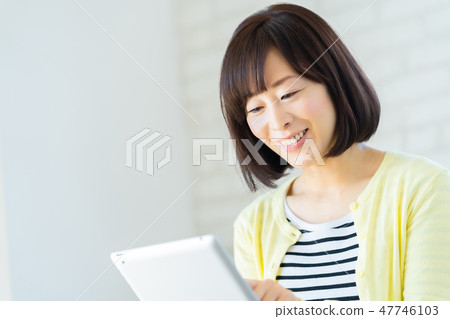 Mother using tablet Middle-aged woman full-time housewife Mother using tablet Middle-aged woman full-time housewife 47746103