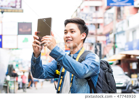 Asian tourist taking photo with tablet computer Asian tourist taking photo with tablet computer 47748910
