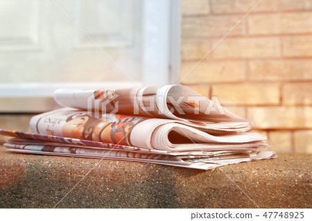 A pile of newspapers on a stairs 47748925